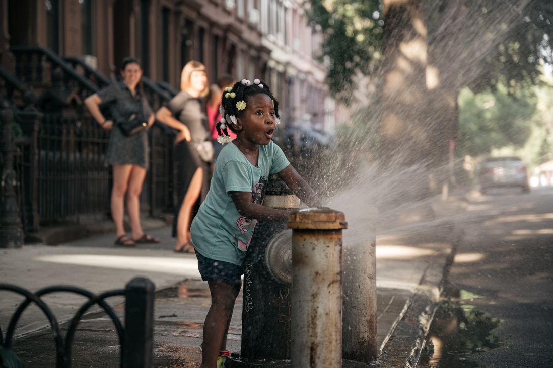 A girl plays in an fire hydrant at a block party in Bed Stuy.